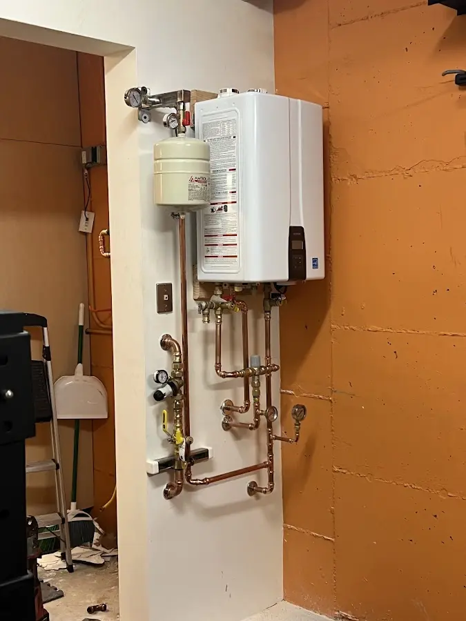 Plumbing technician inspecting water heater connections in Henryetta